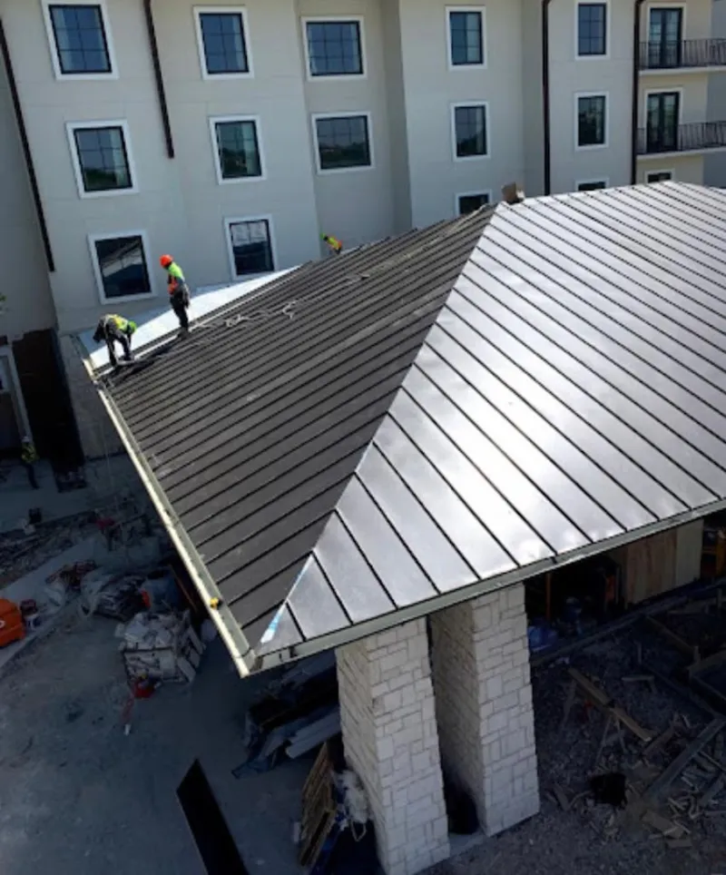 Crew installing standing seam metal roof panels on a commercial project in Beaufort